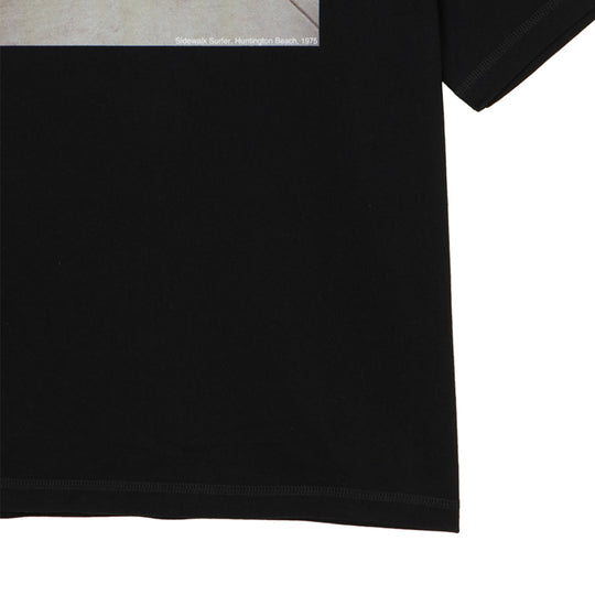 ＜HUGH HOLLANDコラボレーション＞ユニセックス Ｔシャツ ”Sidewalk Surfer (Huntington Beach, 1975)”  ブラック